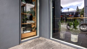 A storefront with a glass door, potted plants, and a sign for a restaurant.