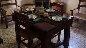 A dining room with a fireplace, a table set for four, and two chairs. - Casa Laino (Belcastro)