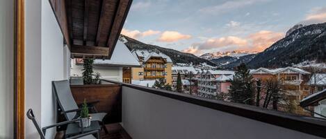 A balcony with a view of a mountain town, featuring a building with a sign that reads "Stifteneck".