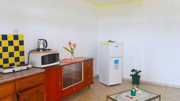Uma cozinha compacta equipada com micro-ondas, torradeira e frigorífico.