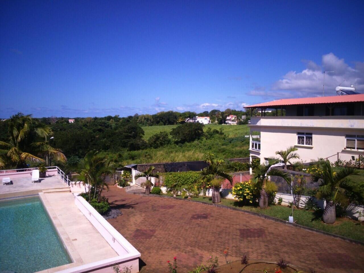 A pool area with a view of a hillside and buildings in the background.