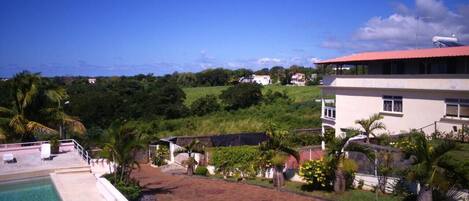 A pool area with a view of a hillside and buildings in the background.