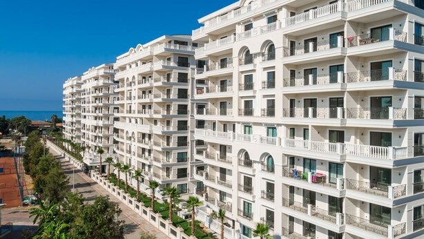 A multi-story hotel with balconies, a clear view of the sea, and a well-maintained exterior. - Alanya Towers C Blok (Alanya)