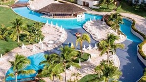 Ein Resort mit mehreren Schwimmbecken, Palmen und Liegebereichen.