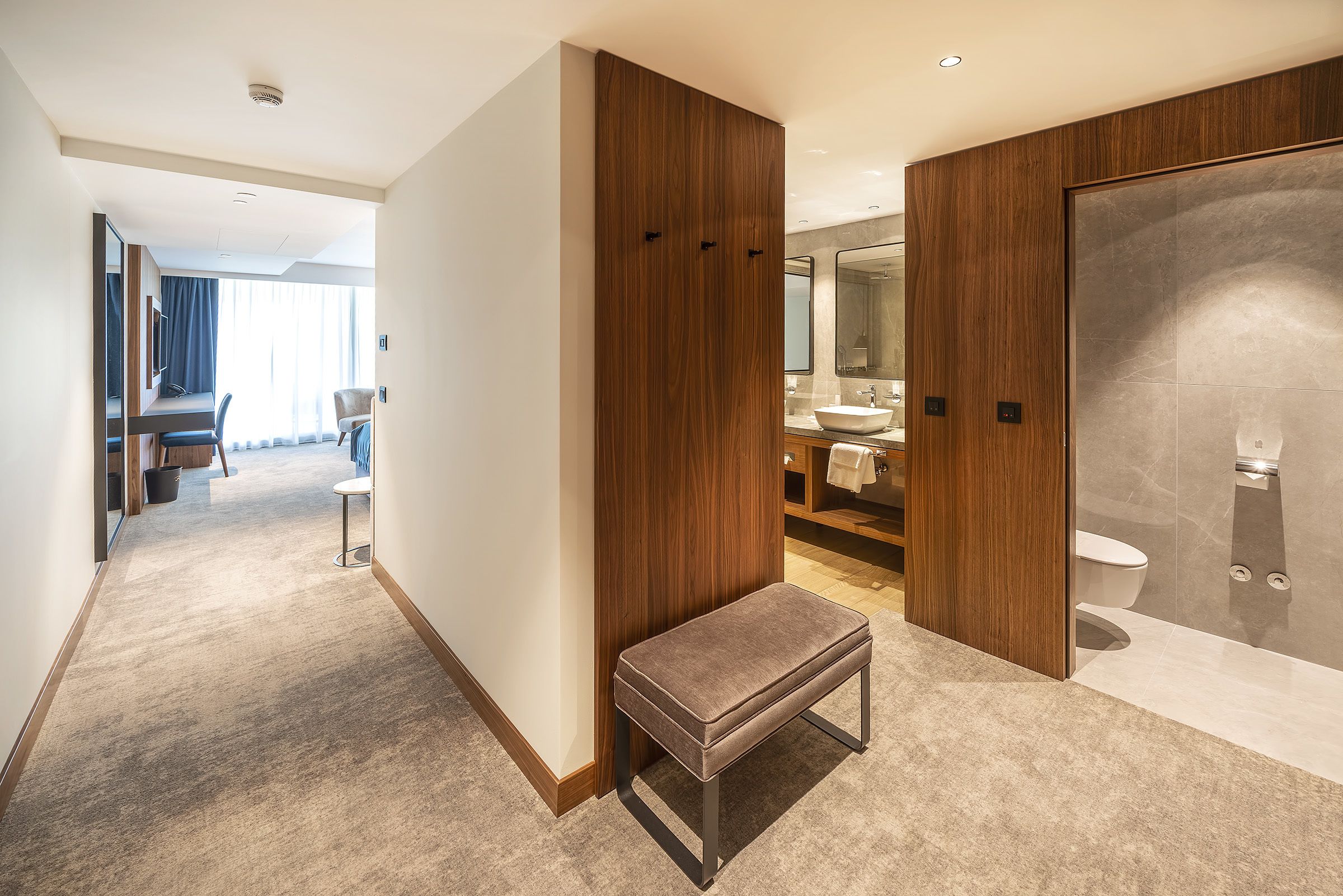 Une salle de bain d’hôtel moderne, dotée d’un grand miroir, d’un lavabo et de toilettes.