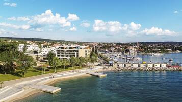 A coastal town with a marina, buildings, and a waterfront promenade.