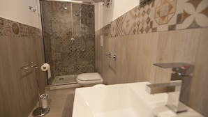 Ein Badezimmer mit Dusche, Toilette und Waschbecken.