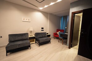 Junior kamer | Een minibar met enkele gratis items, een kluis op de kamer, een bureau