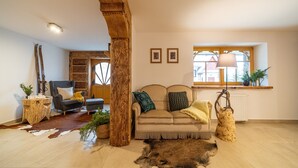A cozy living room with a sofa, a coffee table, and a large wooden beam.