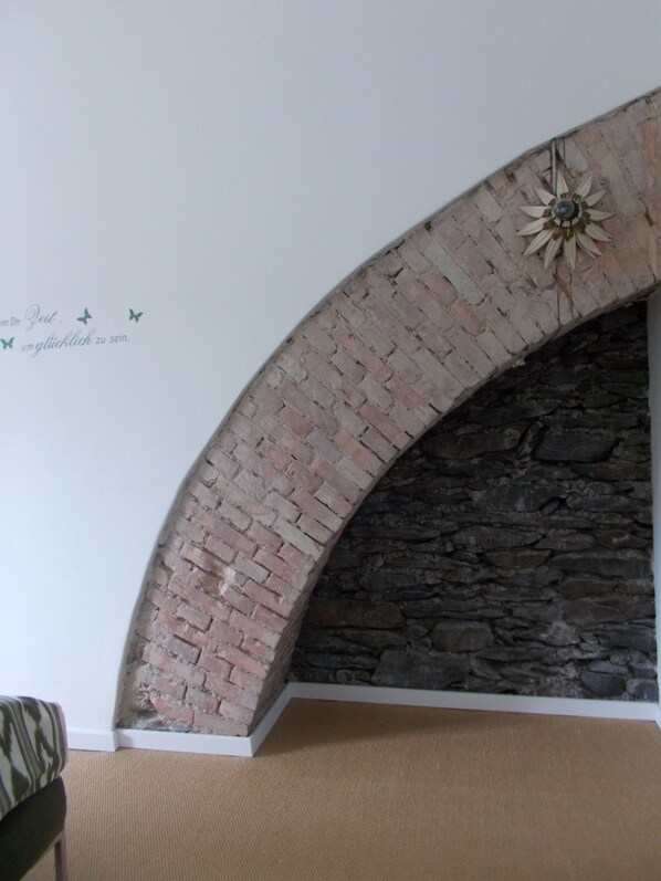 A brick fireplace with a stone wall behind it. - Boutique-Hotel 'Altes Rathaus' (Lahnstein)