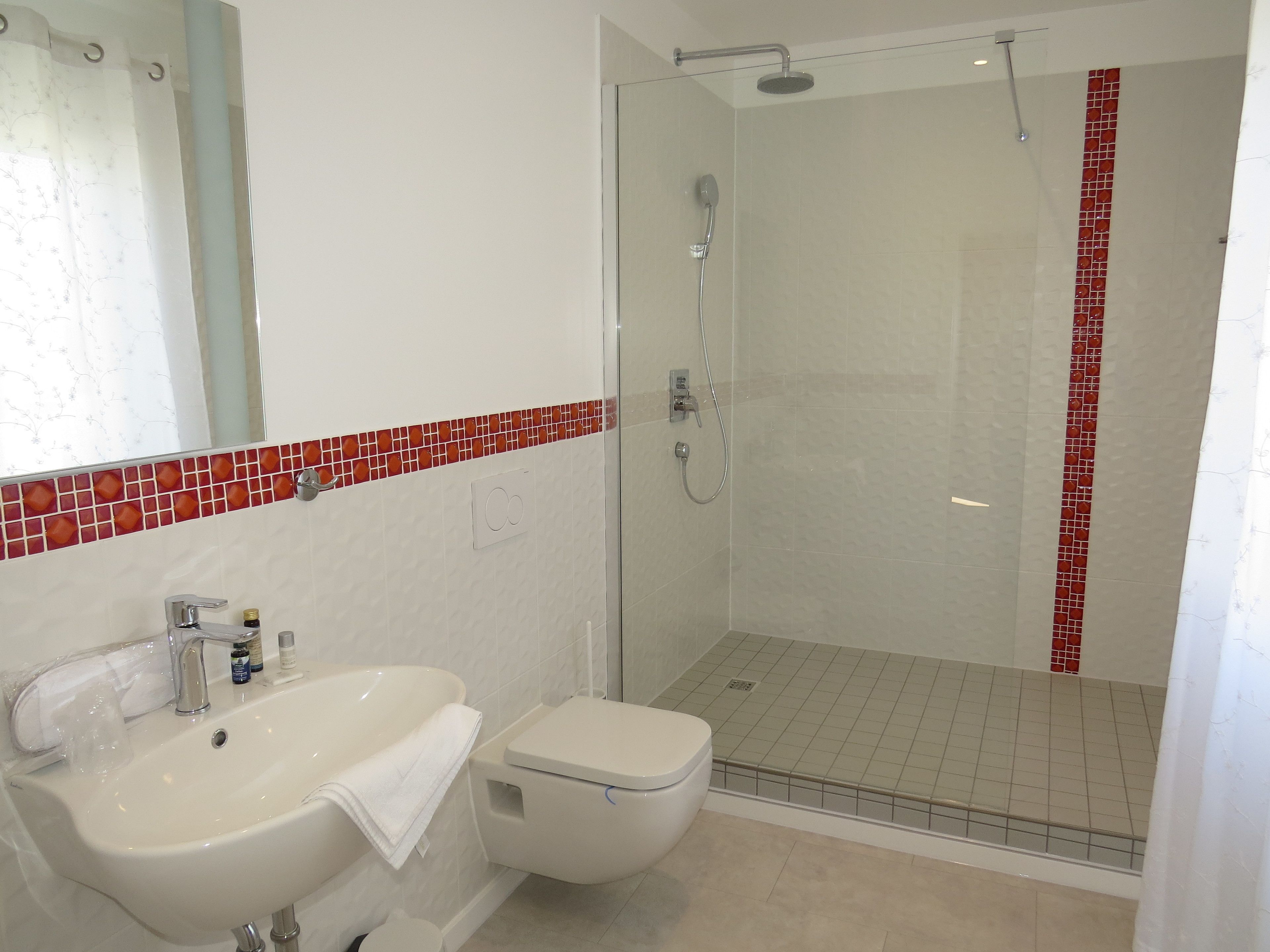 Ein Badezimmer mit Dusche, Waschbecken und Toilette.