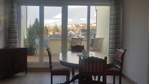 A dining area with a table and chairs, a cabinet, and a large window with curtains. - Boutique-Hotel 'Altes Rathaus' (Lahnstein)