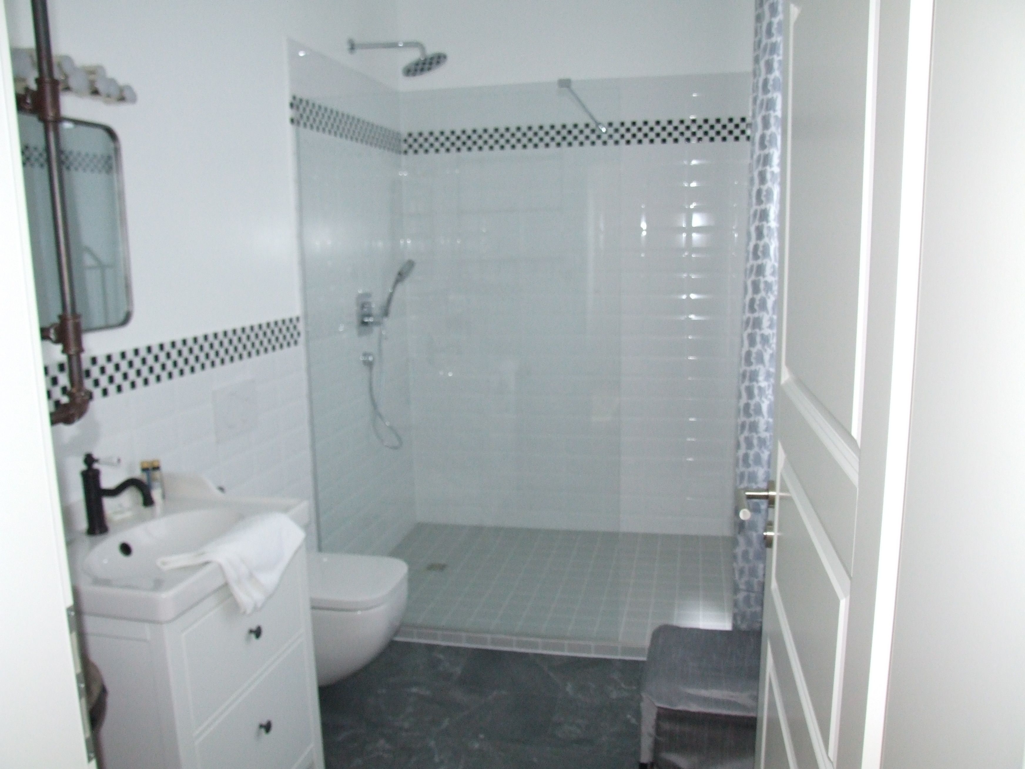 A small, enclosed shower area with a toilet and a sink.