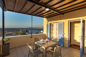 Ein Balkon mit Tisch für zwei Personen, mit Blick auf die Küste.