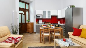 A compact living space with a dining area, kitchen, and seating area. - Otium Old Town Starowiślna (Kraków)