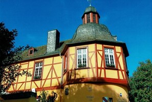 Um edifício tradicional em estilo de enxaimel com uma torre notável e uma placa com a data de 1995.