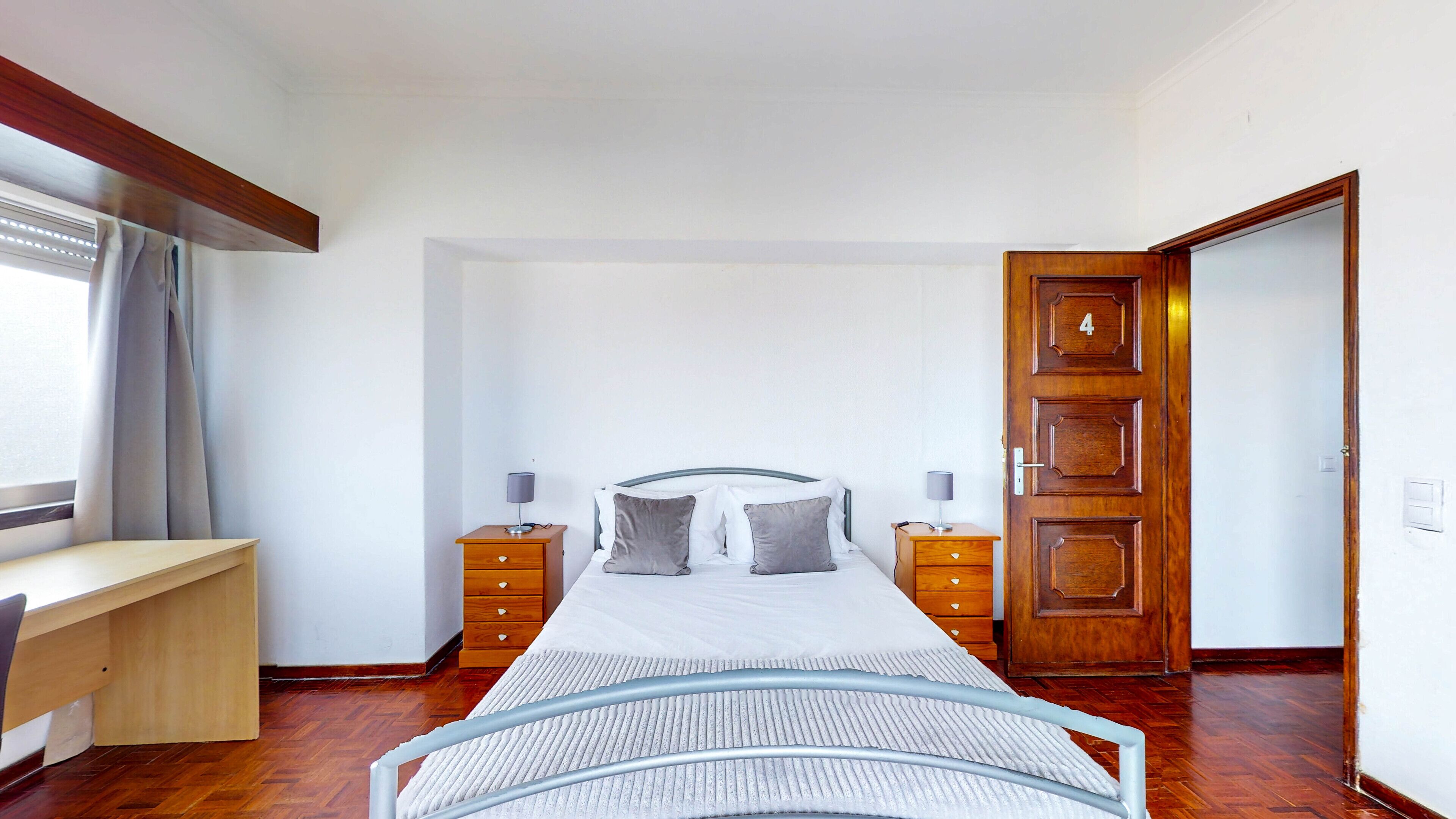 Une chambre à coucher comprenant un lit, des tables de chevet, un bureau et une armoire.