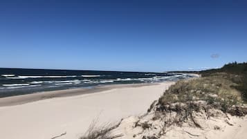 Una spiaggia nelle vicinanze, sabbia bianca, lettini da mare, ombrelloni