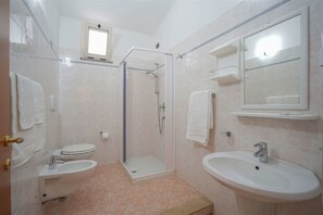 A bathroom with a toilet, bidet, sink, and shower. - Hotel Residence Santa Monica (Ricadi)