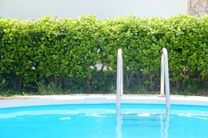 A swimming pool with metal pool ladders, surrounded by a hedge. - Chill & Relax Home with Pool near Beach (Apokoronas)