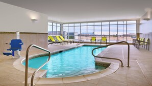 Una piscina interior con vistas despejadas del paisaje urbano a través de grandes ventanales.