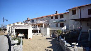 A residential area with a garage, a staircase, and a stone wall. - Apartment Blue Dream 1 & 2 (Malinska-Dubasnica)