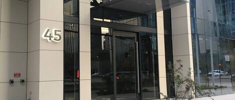 Un edificio moderno con fachada de vidrio y un letrero que dice "ONE Apartments".