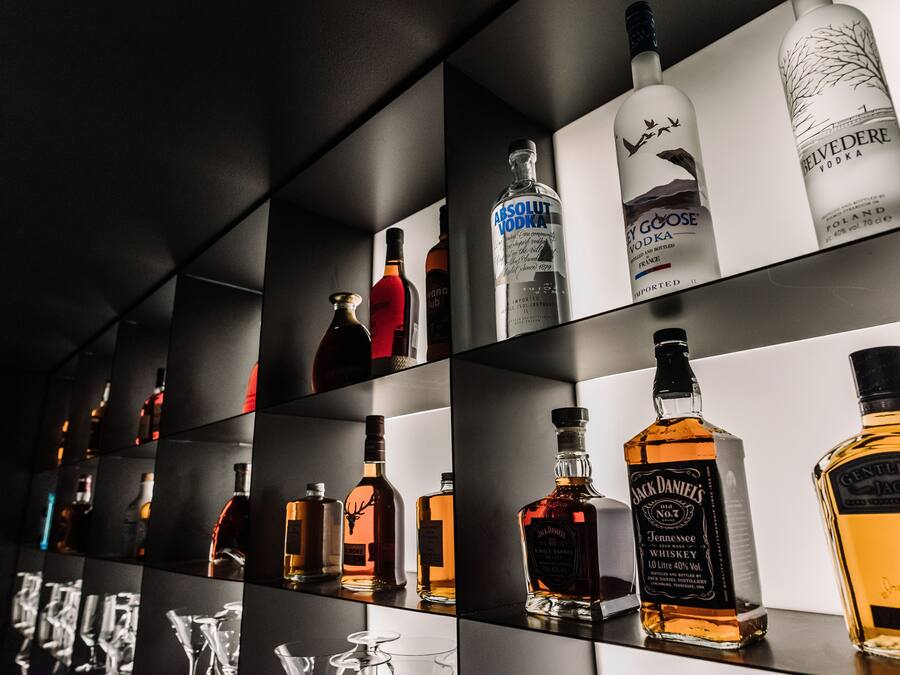 Zona de bar con diversas botellas de licor exhibidas en estantes.