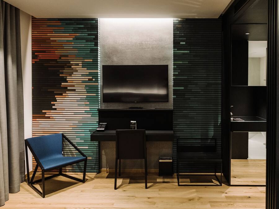 A modern kitchen with a built-in TV, wooden cabinets, and a bar area.