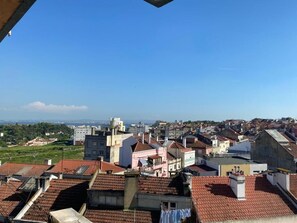 A cityscape with a variety of buildings, including residential and commercial structures, under a clear blue sky. - Olaias Signature Apartment (Lisbon)