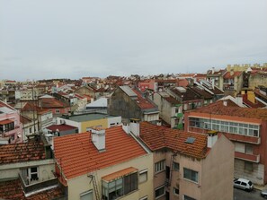 A densely packed urban area with closely built residential buildings, featuring red-tiled roofs and a variety of architectural styles. - Olaias Signature Apartment (Lisbon)