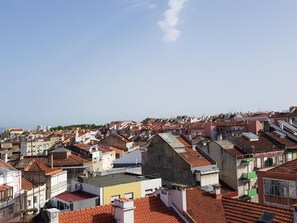 A densely packed urban area with numerous buildings, some with flat roofs and others with sloped roofs. - Olaias Signature Apartment (Lisbon)