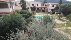 A residential area with multiple houses, a swimming pool, and surrounding greenery. - Il Mirto apartment (Monte Petrosu)