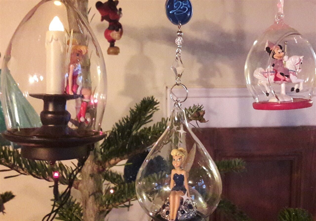 A Christmas tree with ornaments, including a candle holder and figurines.
