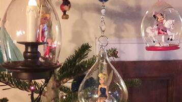 A Christmas tree with ornaments, including a candle holder and figurines.