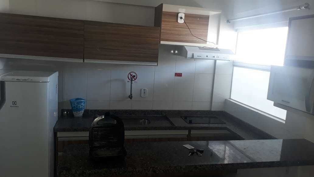 Eine Küche mit Kühlschrank, Mikrowelle, Spüle und Fenster.