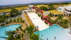 A water park with multiple slides, pools, and a large building with a flat roof.