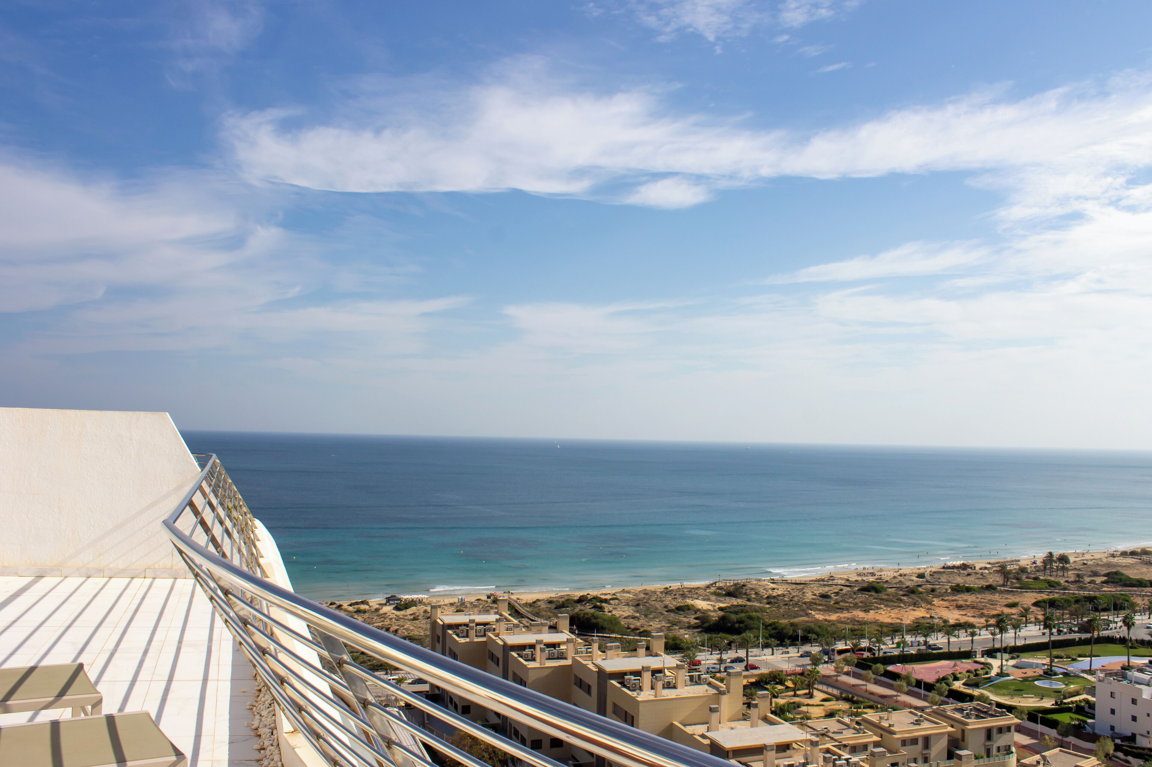 Un paysage urbain côtier offrant une vue sur la mer, des bâtiments et un ciel dégagé.