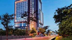 A modern hotel building with a prominent sign at the top. - Movenpick Surabaya City (Surabaya)