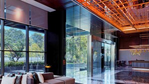 A modern lobby with a sofa, a patterned rug, and a reception desk. - Movenpick Surabaya City (Surabaya)