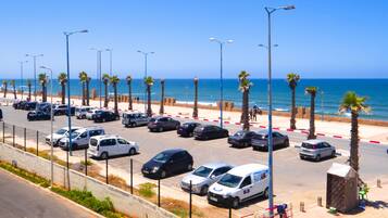 Un parking rempli de voitures, avec vue sur l’océan.