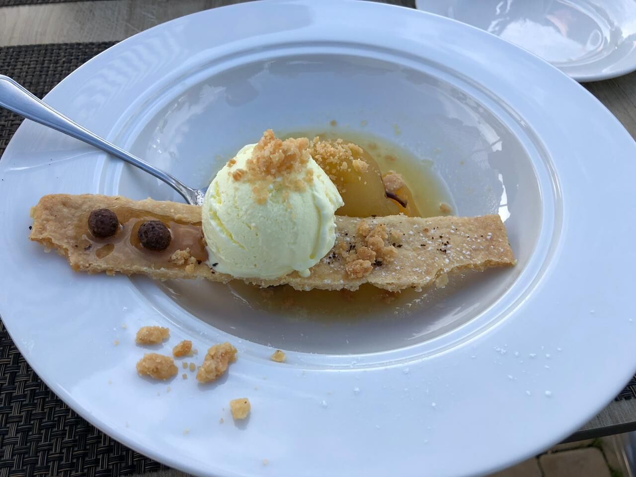 A dessert plate with a scoop of ice cream and a piece of pie.
