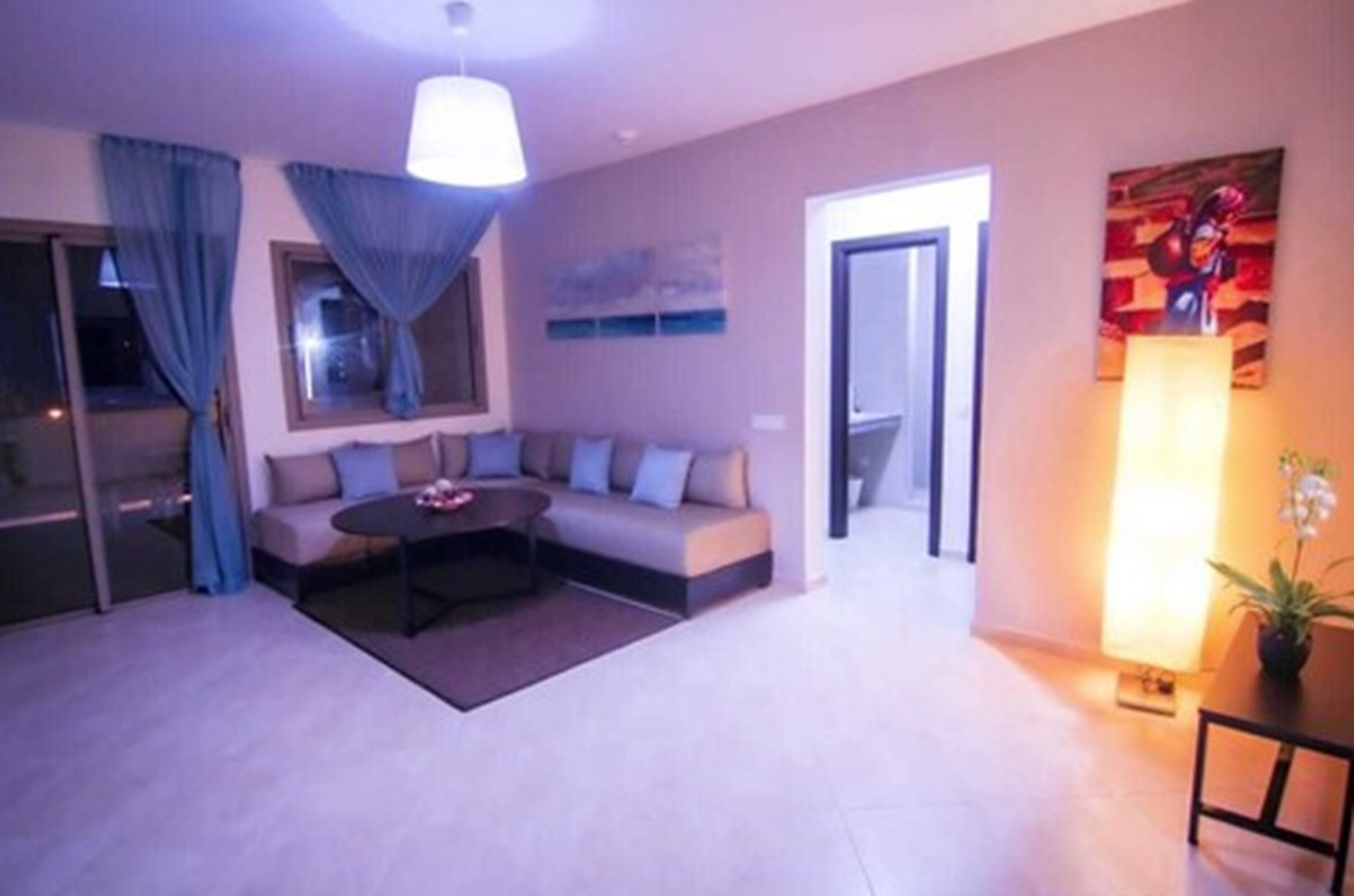 A modern living room with a sofa, coffee table, and a painting on the wall.