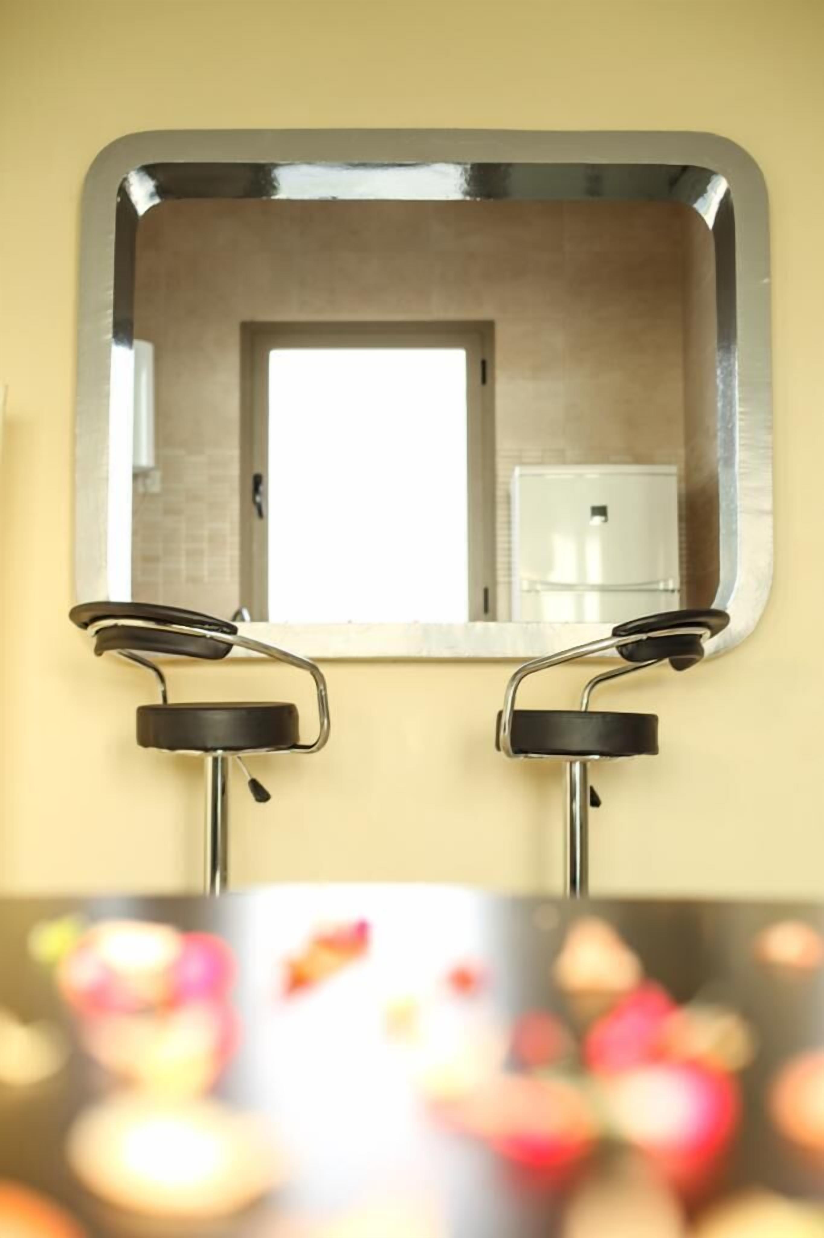 A bathroom with a mirror, two black faucets, and a white toilet visible in the reflection.
