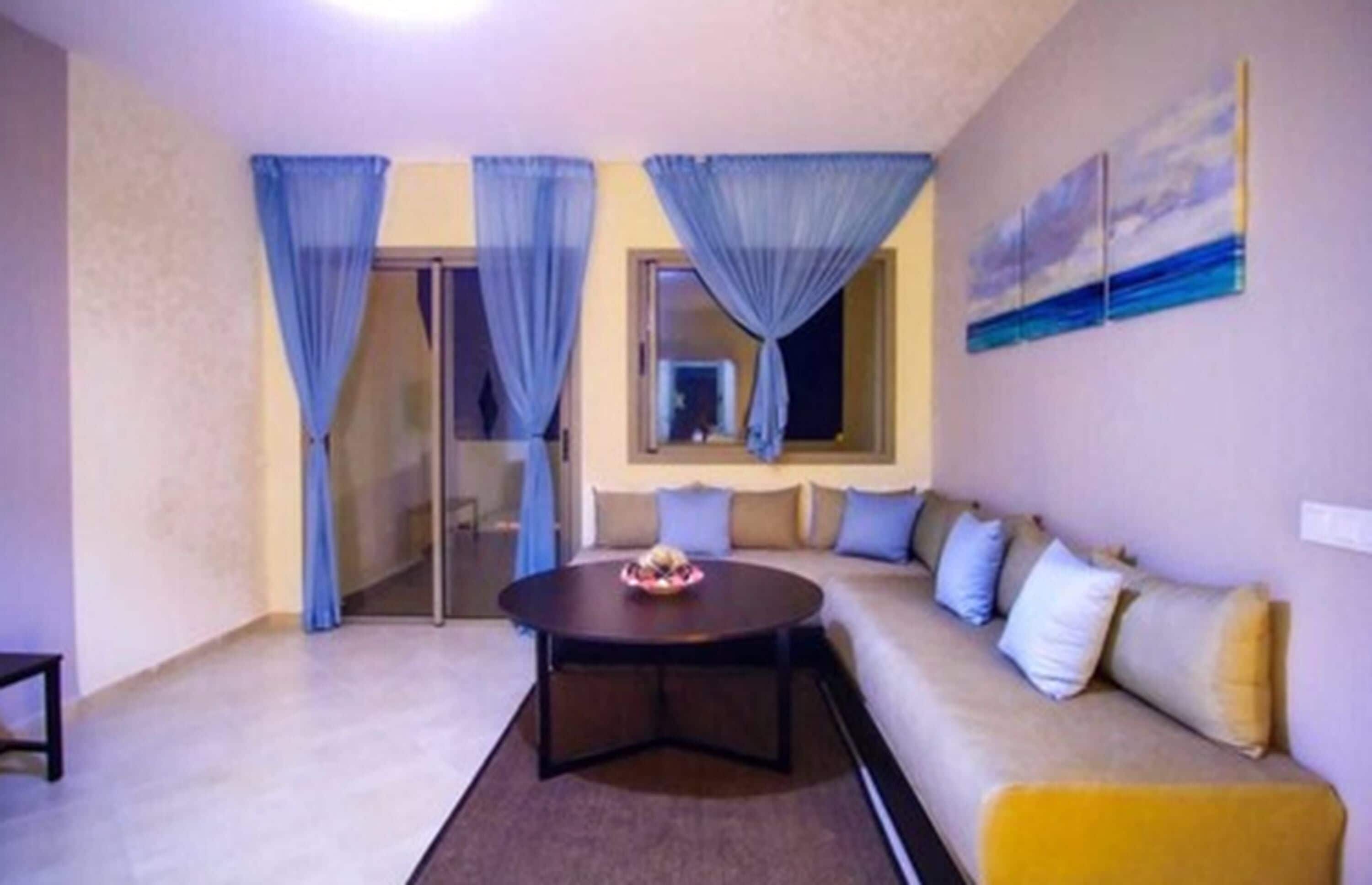 A living room with a sofa, a coffee table, and curtains.
