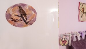 A wall with a circular sticker of a bird and the word "Usignolo". - Holiday rental apartment Le Fate di Campagna (Assisi)