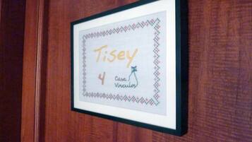 Una obra de arte en marco con el nombre "Tisey" y el número "4", sobre una superficie de madera.