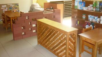 A children's play area with a brick play structure, a wooden table, and a shelf with snacks.