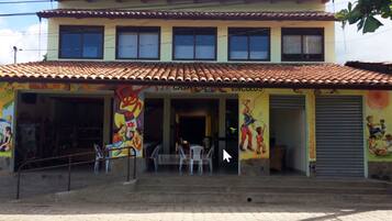 A two-story building with a tiled roof and colorful murals on the exterior walls.