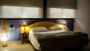 A bedroom with a bed, two bedside lamps, a nightstand, and a wall-mounted lamp. - Hotel Casa Vinculos (Esteli)
